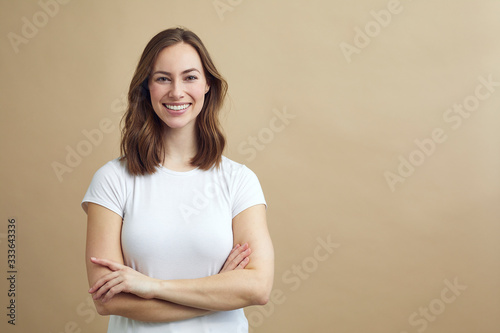 Quadro su tela Portrait of beautiful and confident woman crossing her arms and smiling to the v