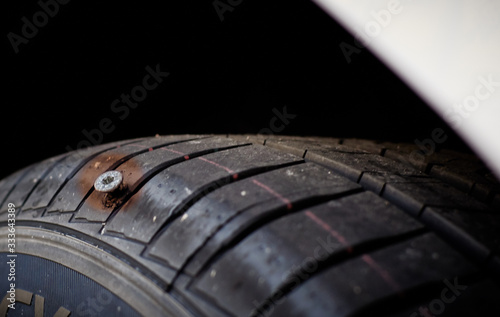 Close-up of a screw nail or iron stuck puncturing car tire © Thomas Marx