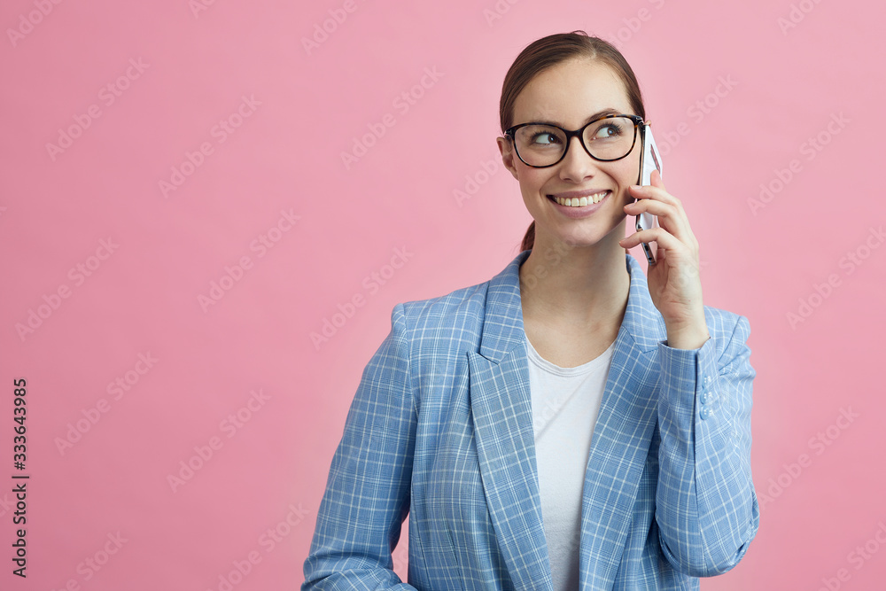 Portrait of businesswoman on a colorful backgound looking confident while talking on the phone