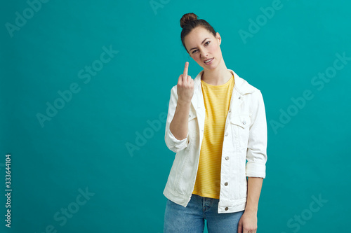 Fotografi Girl is giving the fuck finger to the camera while standing on a colorful backgr