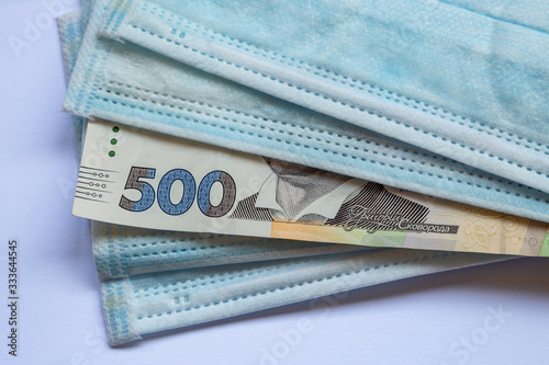 Money notes of Ukraine and a protective mask from a virus. World economic crisis associated with coronovirus.