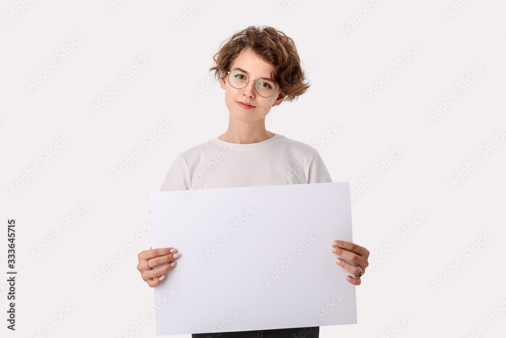 Pretty young woman with eyeglass holding empty blank paper board with copy space for text. Pretty young woman with eyeglass holding empty blank paper board with copy space for text.