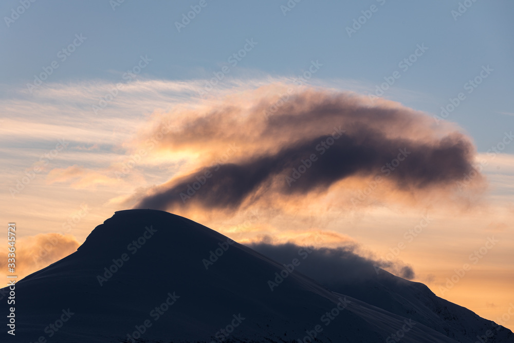 Clouds and mountains backlit by the sun