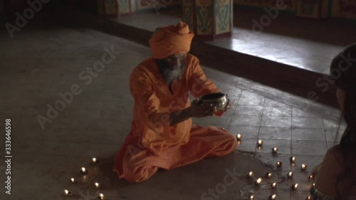 A monk in an ancient temple lights a sacred fire, the priestess brought him the holy grail, the Indian temple of Maharaja