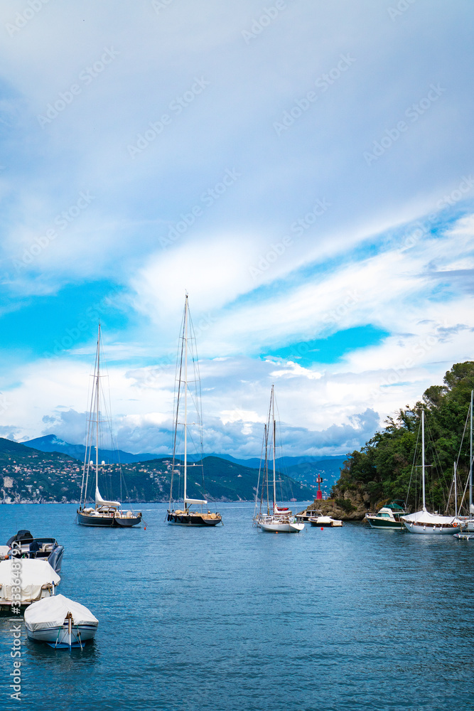 Stunning panoramic view of Portofino, one of the world’s most beautiful seaside towns on the Italian Riviera. Mediterranean landscape of yacht-filled harbour and mountains in the background. Stunning panoramic view of Portofino, one of the world’s most beautiful seaside towns on the Italian Riviera. Mediterranean landscape of yacht-filled harbour and mountains in the background.