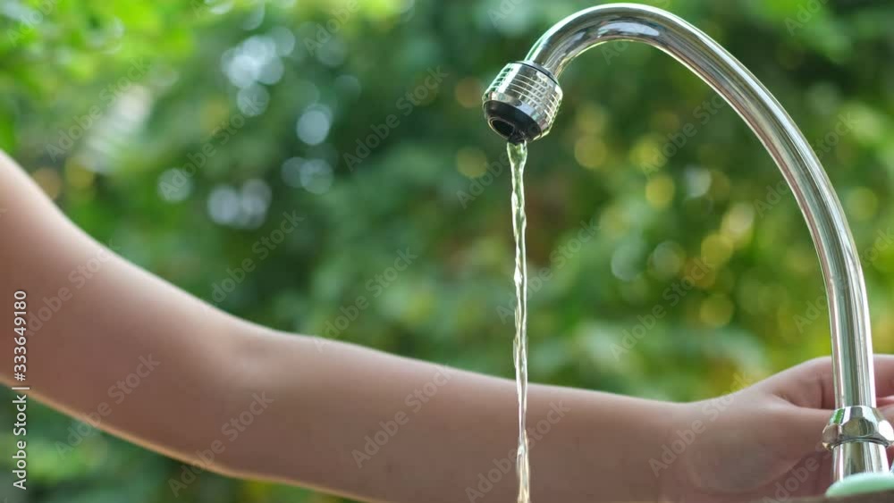 4k slow motion young boy drink water from hand and faucet in garden