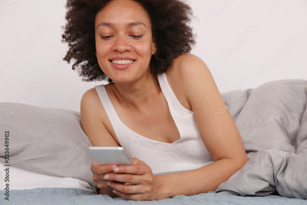 Smiling African American woman using mobile phone at home , Communication and Connection during Coronavirus Self-isolation , Quarantine. Focus on good Smiling African American woman using mobile phone at home , Communication and Connection during Coronavirus Self-isolation , Quarantine. Focus on good