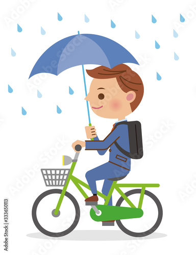 自転車を傘さし運転するビジネスマン