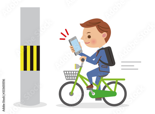 スマホを見ながら自転車を運転するビジネスマン