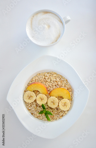 Fresh oatmeal porridge with banana,  for healthy breakfast. Coffee