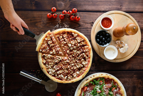Pizza with tomatoes, mozzarella cheese and arugula. Pizza menu.Top view with copy space on dark stone table