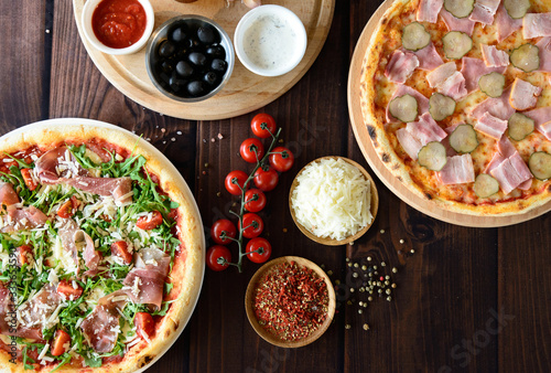 Pizza with tomatoes, mozzarella cheese and arugula. Pizza menu.Top view with copy space on dark stone table