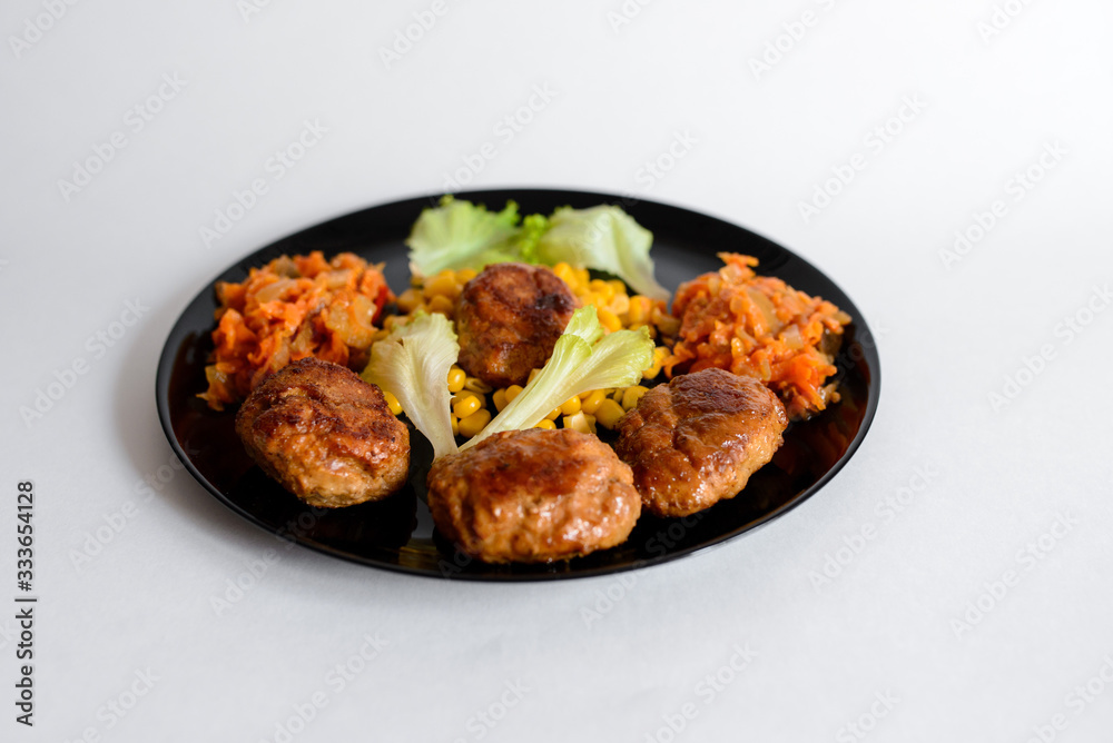 Fototapeta premium Fried chicken cutlet with potato slices served with tomato cherry and corn salad. Traditional belorussian food - roasted minced meat and potato