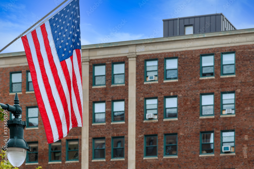 An American flag with an old red brick building in the background
