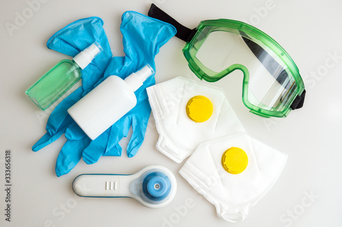 Health Protection Kit for the Coronavirus Pandemic COVID-19. Respirators with a yellow valve, protective glasses, infrared thermometer, medical masks, rubber gloves, hand sanitizers.