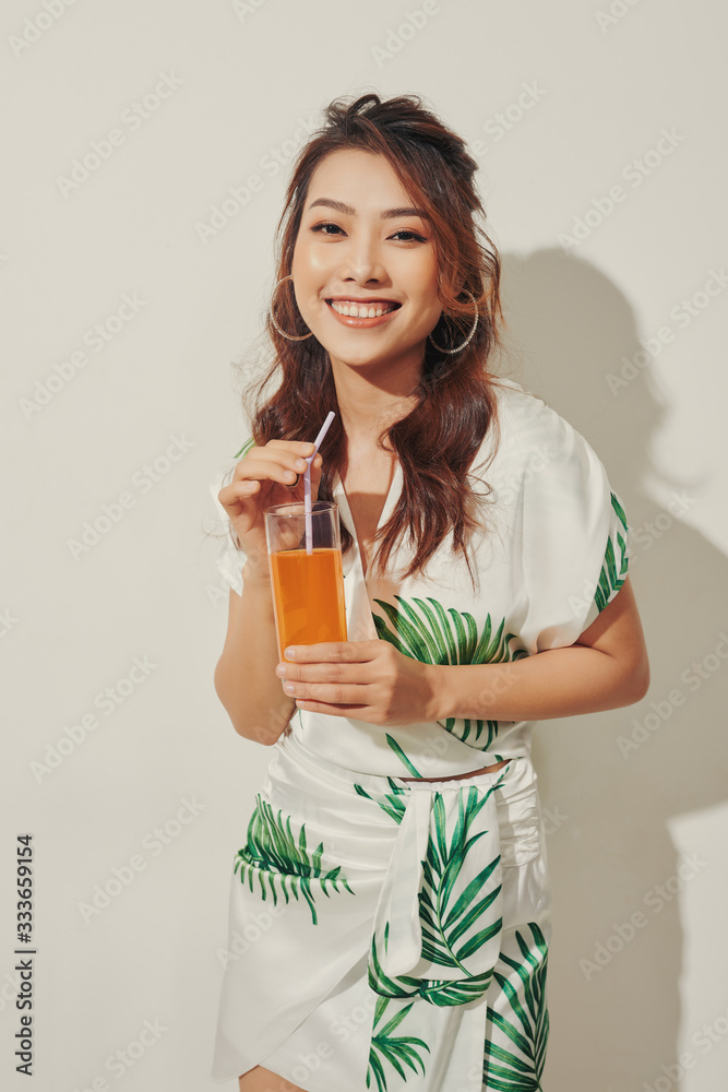 Happy Asian woman in summer casual clothes with a glass of fresh fruit juice drink Happy Asian woman in summer casual clothes with a glass of fresh fruit juice drink