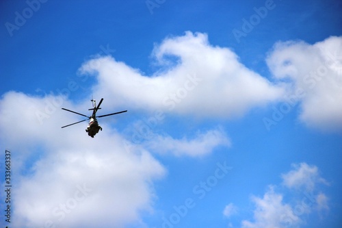 one helicopter in the blue sky with white clouds