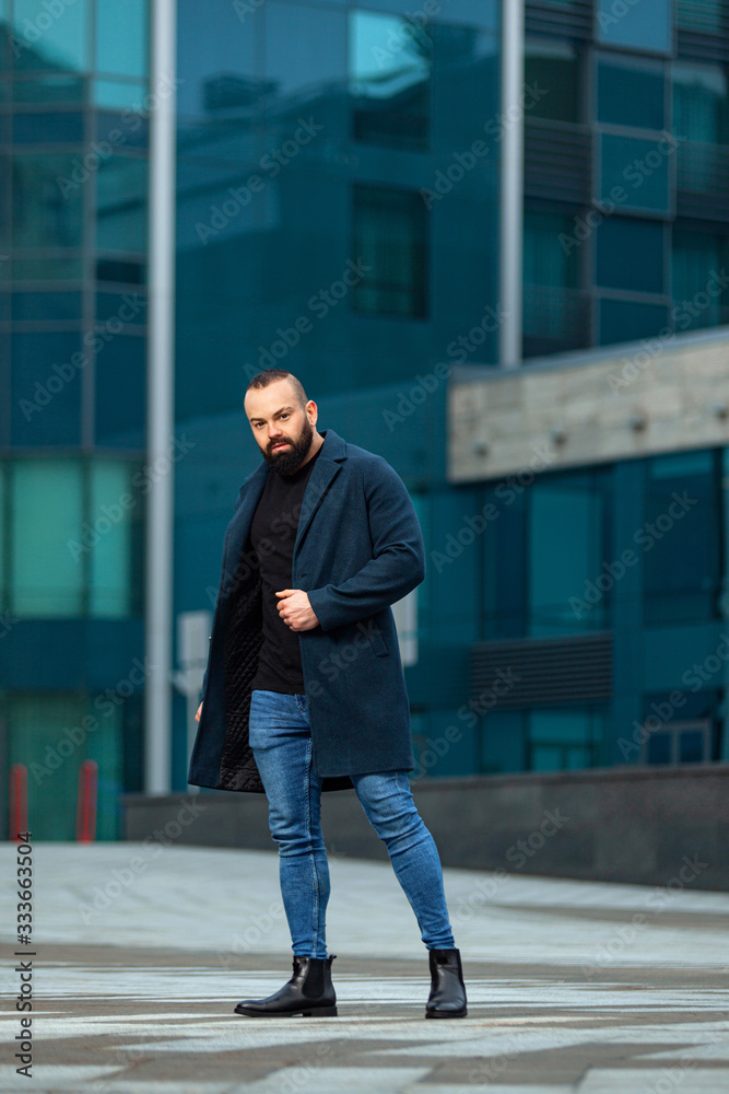 Young business man near business center looking to the future. Autumn or spring mens fashion look. Young business man near business center looking to the future. Autumn or spring mens fashion look.