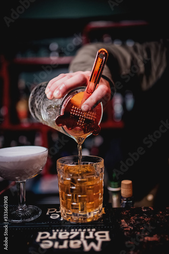 bartender pours a cocktail photo