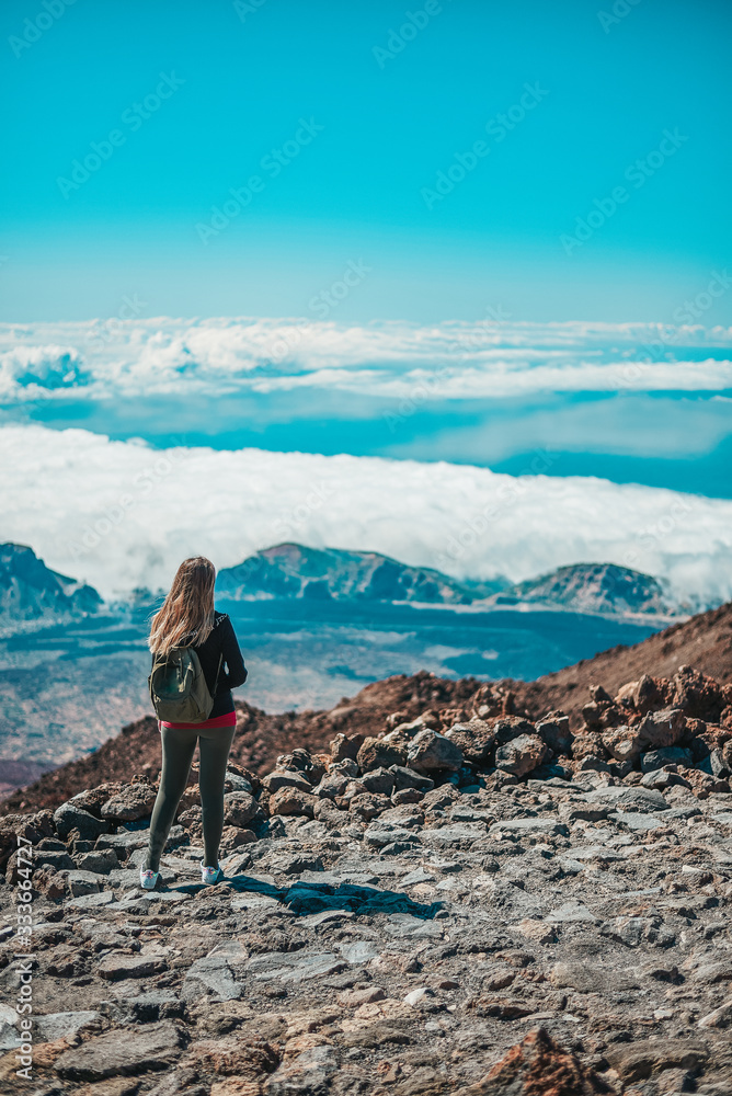 Young woman contemplating the entire Tenerife island from the top of the Teide Volcano