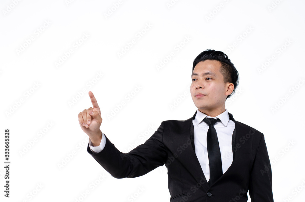 Young business man wearing black suit using finger on augmented reality touch screen against white background Young business man wearing black suit using finger on augmented reality touch screen against white background
