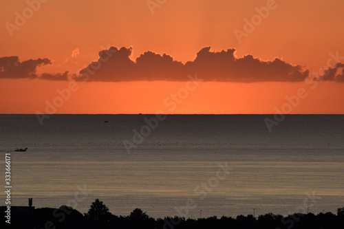 Alba dalle colline di Riccione con vivaio di molluschi sullo sfondo e barca peschereccio photo