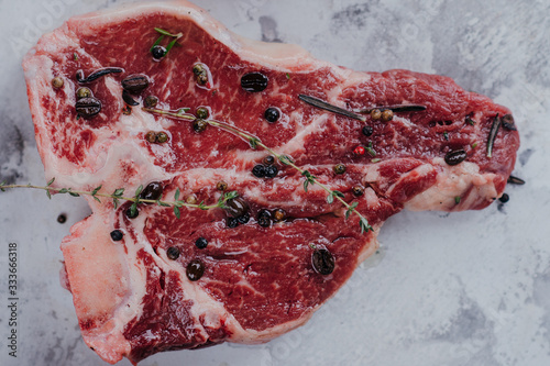 Raw T-bone close up photo on a marble desk.