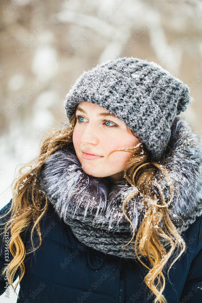 A girl of European appearance walks in the Park, forest, winter and snow, dressed in warm clothes, hat, jacket, scarf, rest, Hiking A girl of European appearance walks in the Park, forest, winter and snow, dressed in warm clothes, hat, jacket, scarf, rest, Hiking