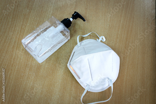 Medical masks and sanitizing gel on wooden floors