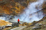 A man stands near a geothermal source. Sulfur vapor in Iceland