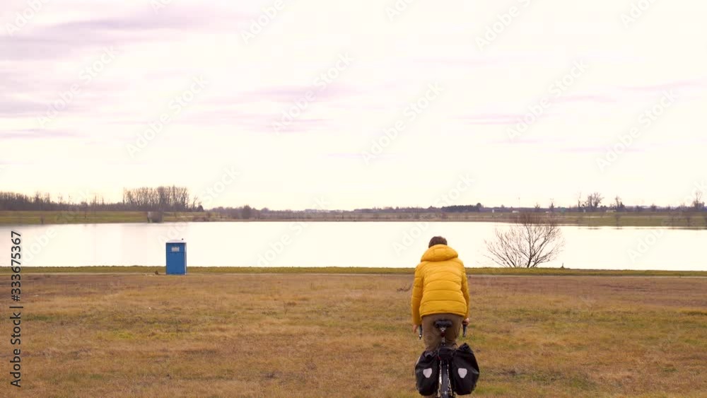 Establishing shot of bicycle traveler stopping to use the temporary toilet. Establishing shot of bicycle traveler stopping to use the temporary toilet.