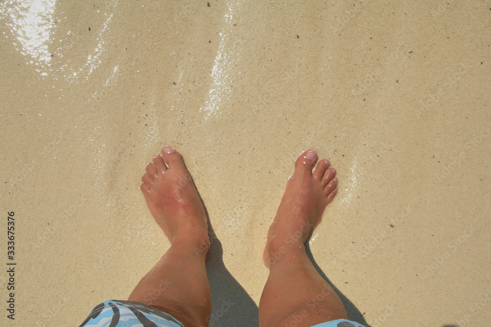 Bare feet in the water on a caribbean beach