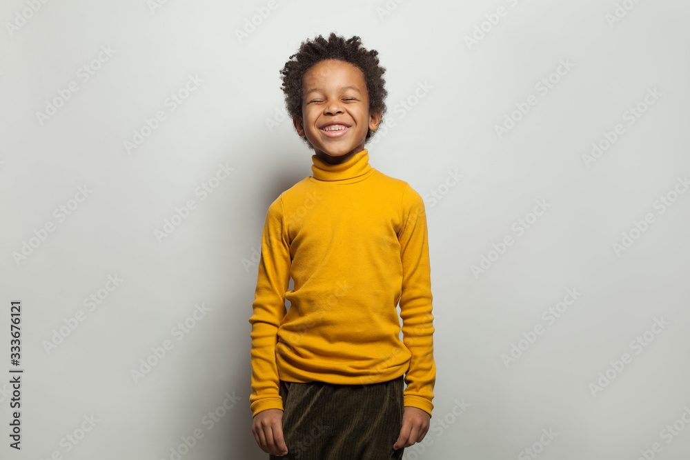 Black kid laughing. Happy little boy on white background