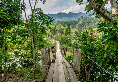Wooden scary hanging bridge in amazing jungle near Bukit Barisan mountain range Leuser ecosystem in Banda Aceh, Sumatra, Indonesia photo