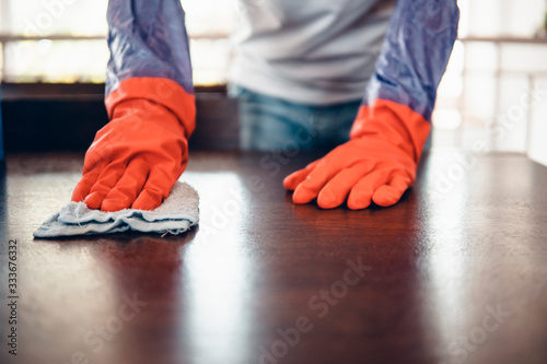 Cropped shot of an asian man cleaning a kitchen table at home