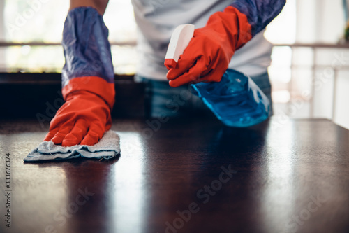 Cropped shot of an asian man cleaning a kitchen table at home