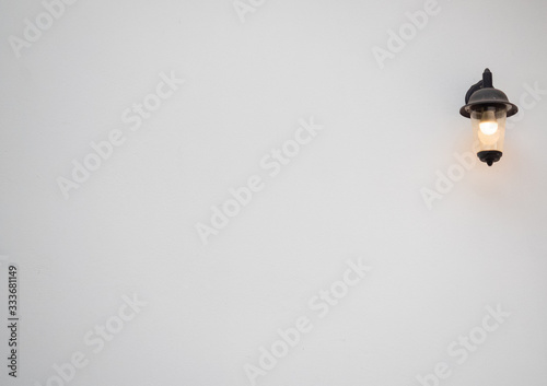 Warm light, led lamp in an antique lamp on a white wall in a minimalist style with copy space.