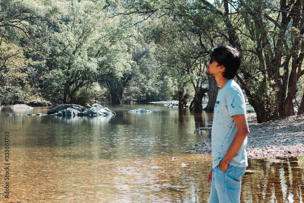 Portrait of an Indian man standing in front of river in the Polo Forest in Gujarat, India Portrait of an Indian man standing in front of river in the Polo Forest in Gujarat, India
