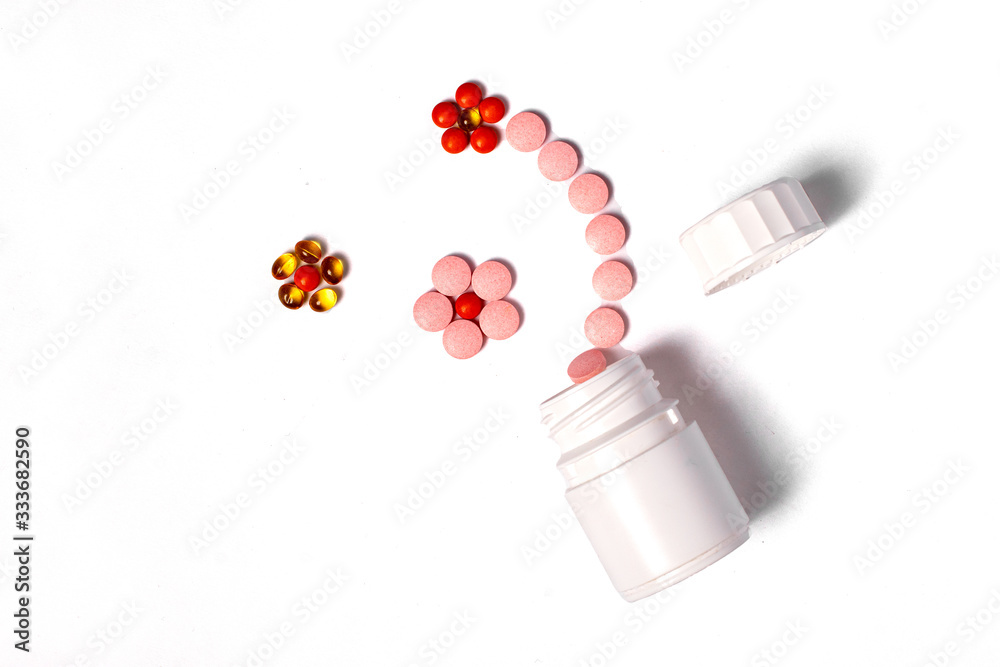 White plastic bottle with medicines and vitamines. tematic health. rose, yellow and red medicines.