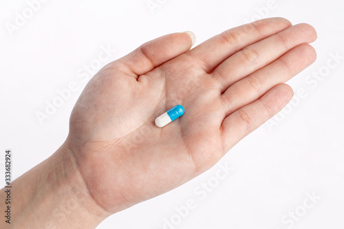 Blue and white pill in hand. medicines and vitamins