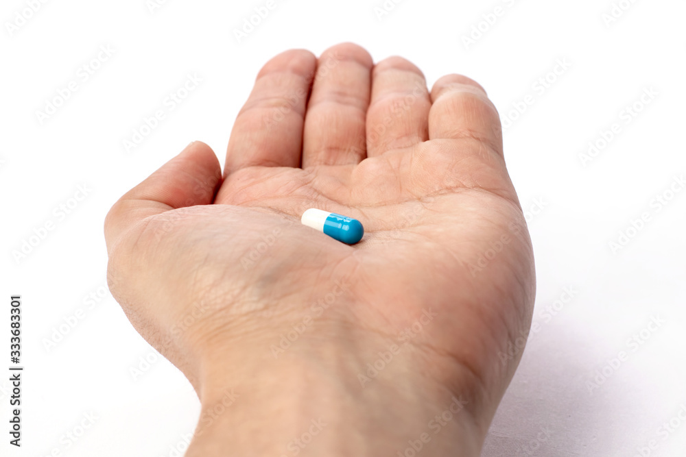 Blue pill in hand. medicines and vitamins Blue pill in hand. medicines and vitamins