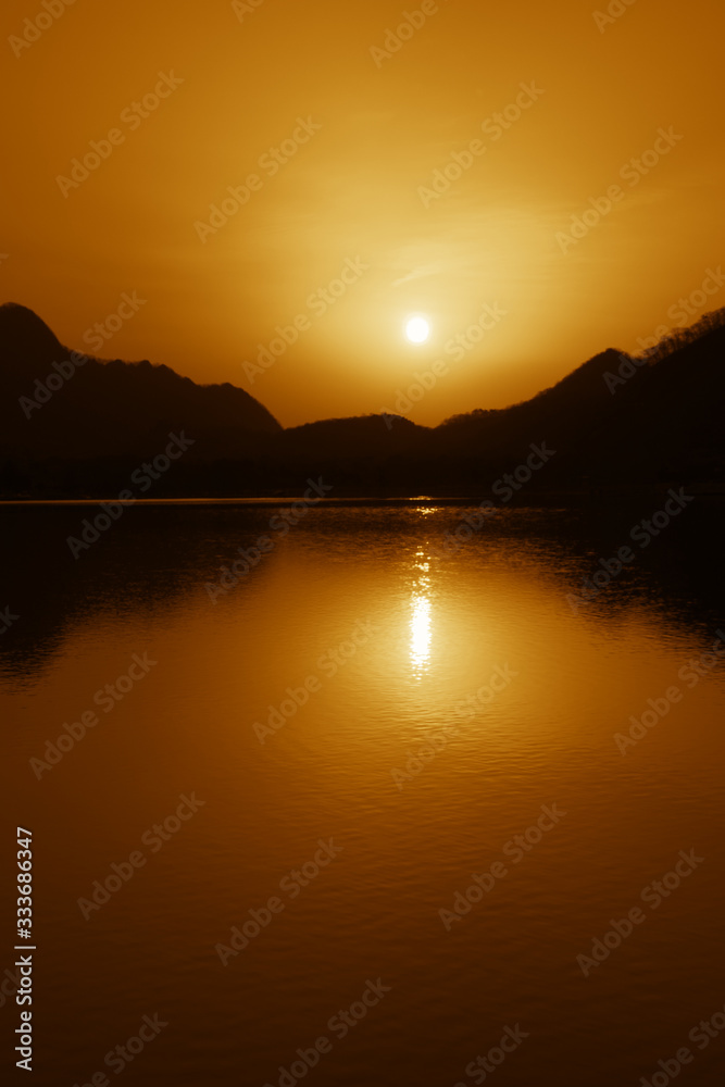 湖に映る夜明けの太陽