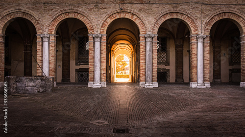 Arches of Palace Venieri with golden hour sunlight shining in through the entrance doorway  Recanati  Italy