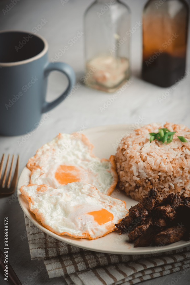 Tapsilog is a famous Filipino breakfast that typically consists of  cured fried beef (called tapa),  fried rice and eggs.