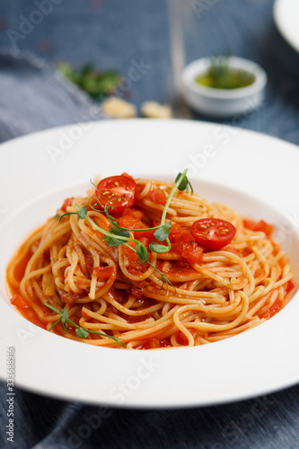 bolognese pasta with cherry tomatoes on white plate