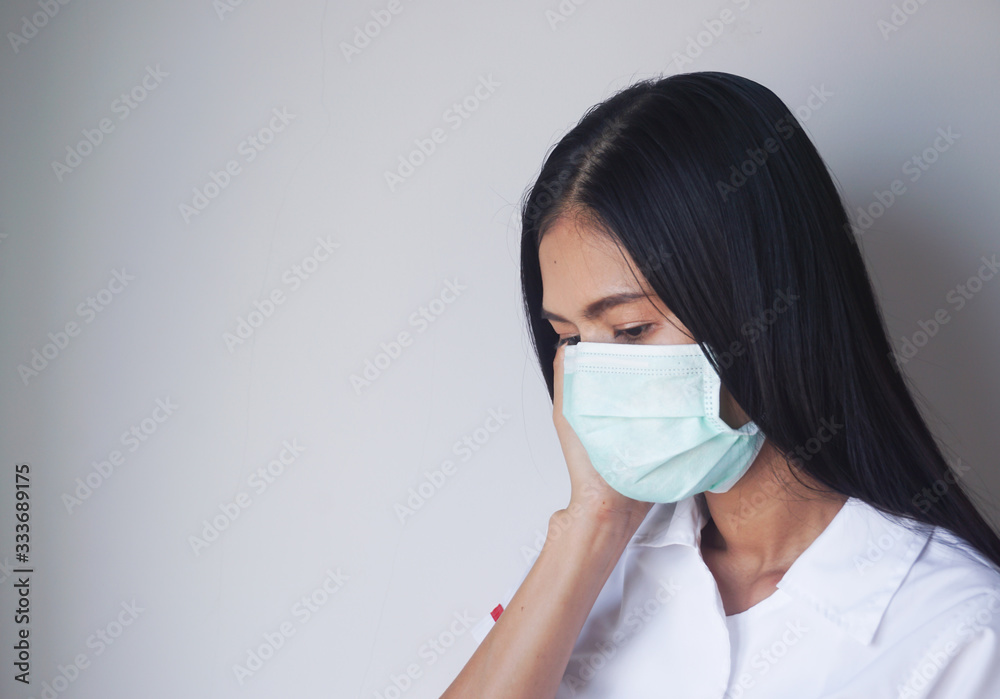 Young woman wearing a face mask. Woman sick. Hand touch the face..