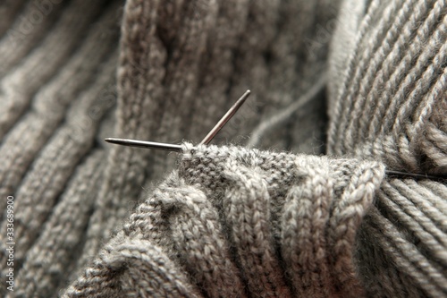 Vintage Knitting needles and grey yarn on scarf background -natural wool knitting background. home hobby concept - what to do at home. leisure time