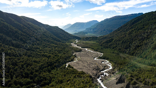 Aerial view on green valley with river stream surrounded by mountains. Nahuel Huapi National Park in Patagonia, Argentina 