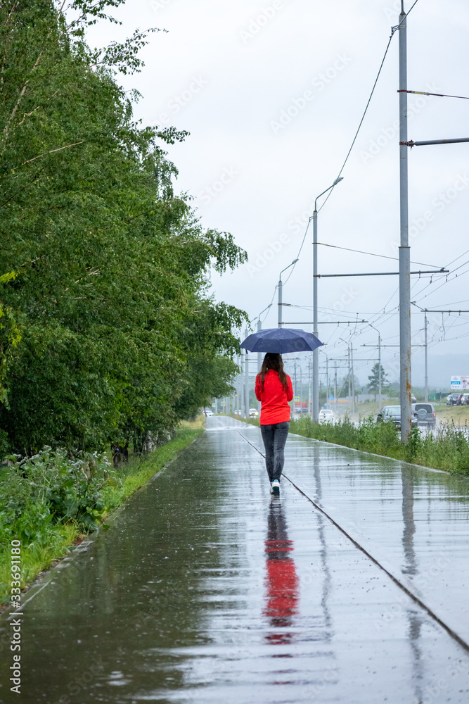 Young woman walking with umbrella in a rainy day
