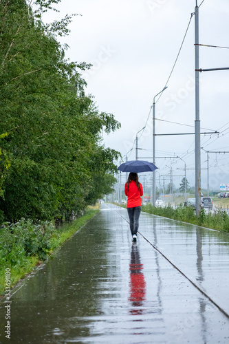 Obraz na płótnie Young woman walking with umbrella in a rainy day w salonie